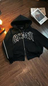 boxy-fit, black zip-up hoodie featuring Gothic/Old English style lettering